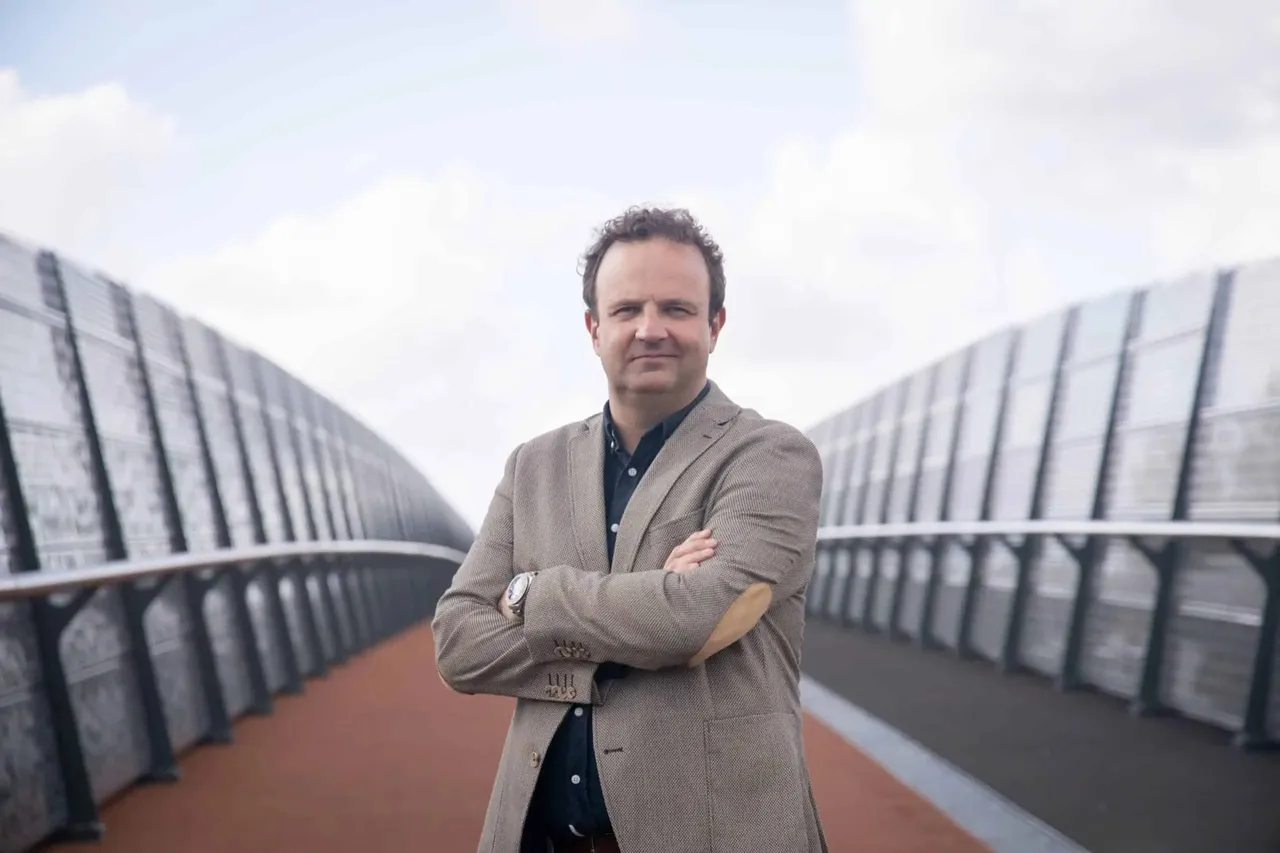 Marc van Rongen met de armen over elkaar op een brug